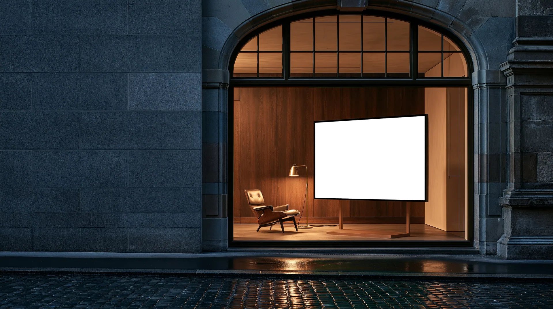 An arched shop window with walnut panelling, a leather lounge chair and a screen showing the Kern furniture shop