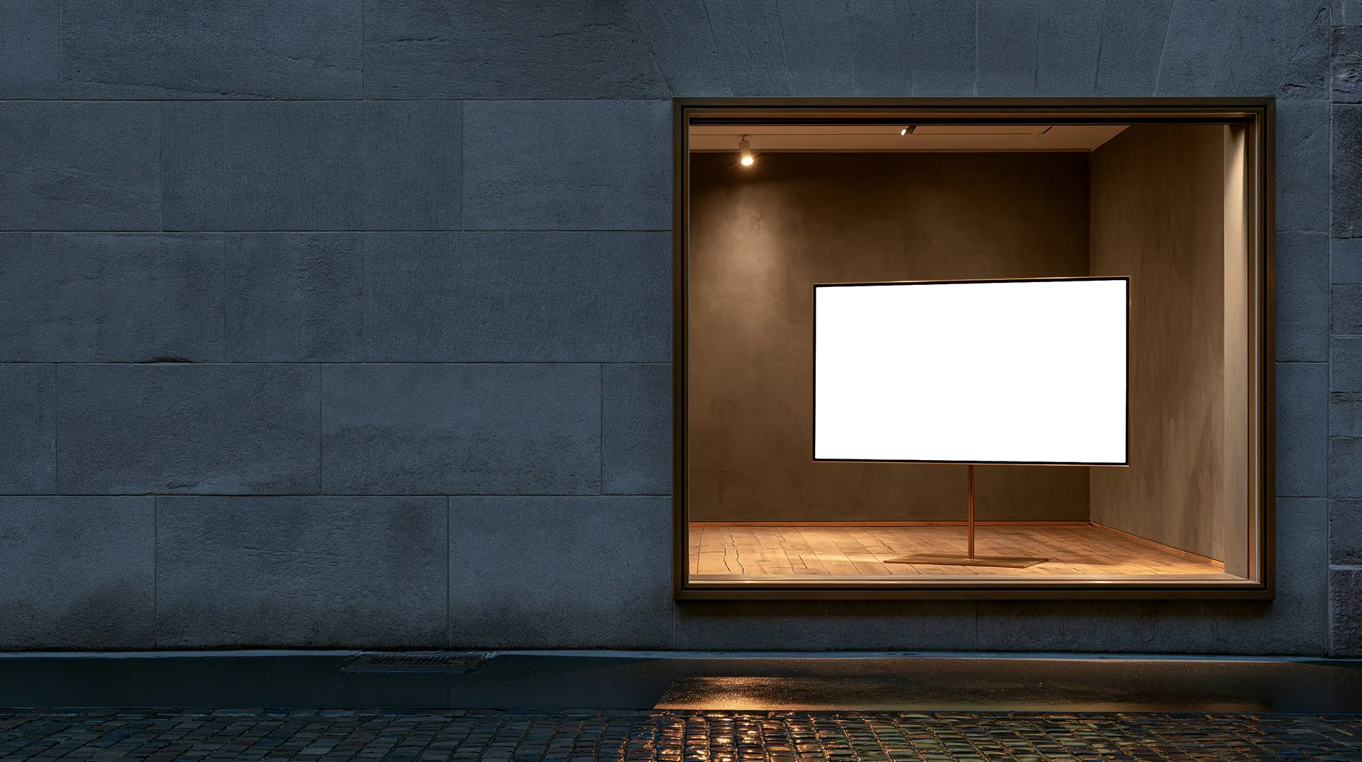 An empty shop window with a bare oak floor and a single spotlight, its screen waiting for the next website